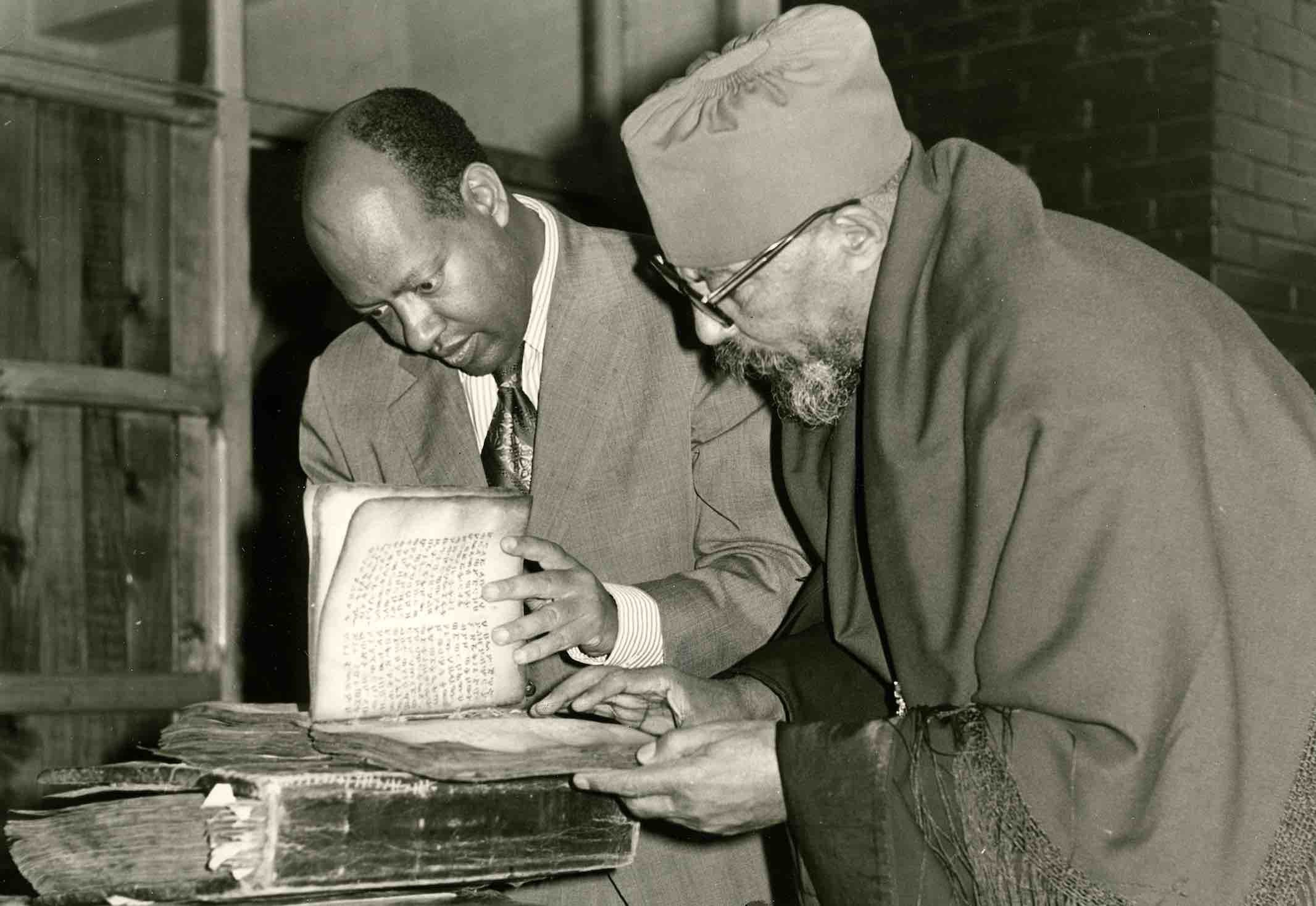 In 1974, Dr. Sergew Hable Selassie (left) shows an EMML manuscript to the patriarch of the Ethiopian church, Abuna Theophilos in Addis Ababa